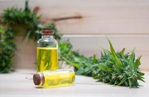 Oil cannabidiol CBD with bud marijuana on wood background photo