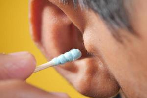 men using ear cotton bar close up photo
