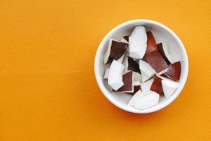 slice of fresh coconut on orange background photo