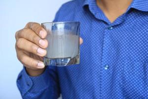 sosteniendo un vaso de agua sucia foto