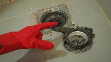 Drain cleaning. Clogged and dirty sewer pipes floor drain. Full of hair and accumulated clogged grease. Maintenance the floor drain sewage system in bathroom. fixing clean wash and unclog a drain. photo