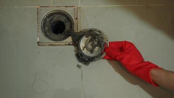 Drain cleaning. Clogged and dirty sewer pipes floor drain. Full of hair and accumulated clogged grease. Maintenance the floor drain sewage system in bathroom. fixing clean wash and unclog a drain. photo