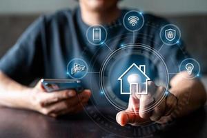 Man using mobile phone to control various devices in the house, Smart home technology concept photo