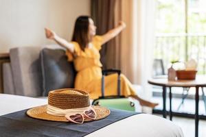 Young woman traveler sitting and relaxing in a hotel room while on summer vacation, Travel lifestyle concept photo