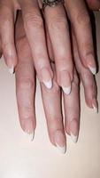 Acrylic nail extension, manicure, nail correction, hands in the foreground. Reflective design. photo