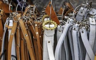Leather belts in a market photo