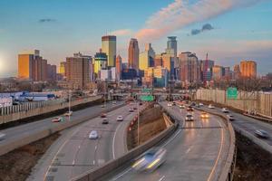 hermoso horizonte de la ciudad del centro de minneapolis con semáforo al atardecer foto