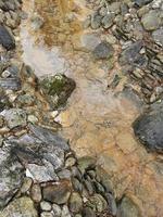 Cold mountain stream among the stones photo