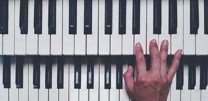 vista superior de la mano tocando el piano o el teclado de tono elegido en estilo de color vintage. concepto de objeto, música e instrumento foto