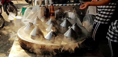 Close up people cooking stove or dim sum with smoke and sunlight in the morning. Street food market and Beauty of Nature concept photo