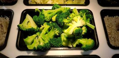 Fresh sliced broccoli in black for sale at freshness salad market. Healthy or Diet food and Vegetable concept photo