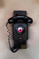 Black vintage telephone install or isolated on rough wall background. Technology , Communication device and Retro object concept photo
