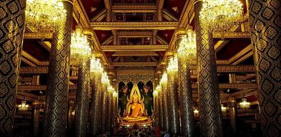 Big golden monk statue at Phitsanulok, Thailand. Beautiful interior design and art building in Thai ancient style. Landmark of travel for tourism people. photo