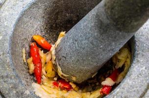 Pepper and garlic pounded in a stone mortar photo