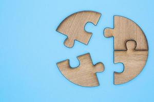 Wooden jigsaw puzzle on a blue background.  Wooden jigsaw puzzle on a blue background.  Team business concept photo