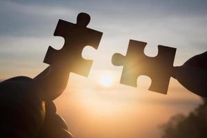 Silhouette Woman hands connecting couple puzzle piece against sunrise, Business solutions, target, success, goals and strategy concepts photo