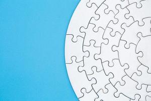 white jigsaw puzzle pieces on blue background,  Copy space. photo
