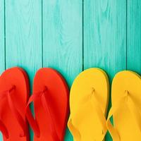 Colorful flip flops on blue wooden background with copy space. Top view photo
