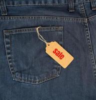 brown paper tag on a rope tied to blue jeans photo