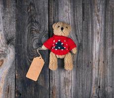 small brown old teddy bear with a paper blank tag photo