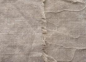 Gray linen fabric with frayed edges with thread photo