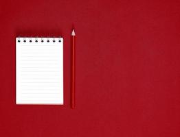 notebook with empty white sheets in line and red wooden pencil photo