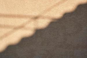 fragment of yellow cement wall with shadow photo