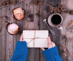 female hand in a blue knitted sweater holding a stack of old empty cards tied with a rope photo