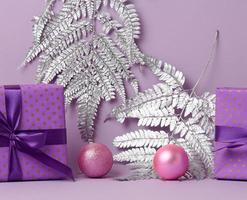 boxes packed in festive purple paper and tied with silk ribbon on a purple background, gift, surprise photo