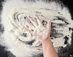 white wheat flour scattered on a black background photo