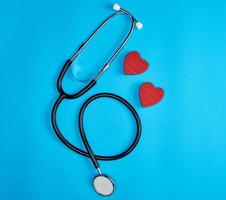 black medical stethoscope and wooden red heart photo