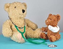 teddy bear with bandaged paw and stethoscope photo