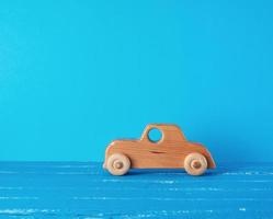 coche infantil de madera sobre un fondo azul foto