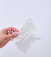 female hand holding a clean white paper napkin for face photo