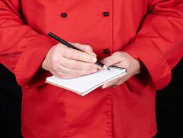 chef in red uniform  holding a blank notebook photo