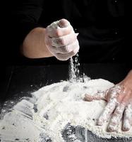 white wheat flour on a black wooden table photo