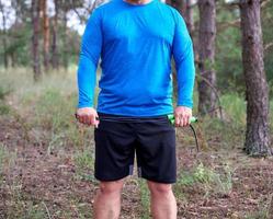 adult man in blue clothes holding a jump rope for playing sports photo