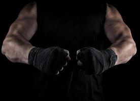 two men's hands wrapped in a black bandage, body parts in front of the torso photo