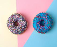 round baked donut with colored sugar sprinkles and with blue sugar glaze photo