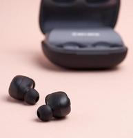 black wireless little earphones and a charging box photo