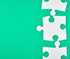 blank white big puzzles on green background photo