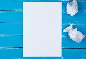 blank white rectangular sheet of paper and crumpled pieces of paper photo