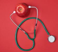 Ripe apple and green medical stethoscope photo