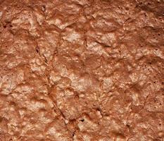 fragment of baked brownie chocolate cake with cracked surface photo