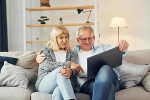 Internet connection. Using laptop. Senior man and woman is together at home photo