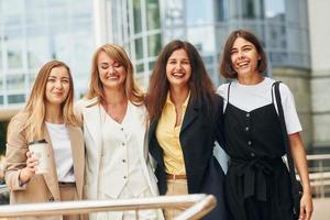 Women in formal wear is outdoors in the city together photo