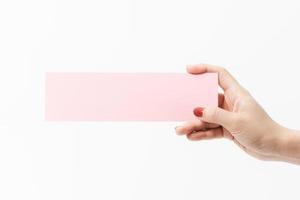 Close up women holding pink blank paper on white background. photo