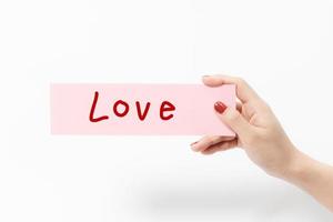 Close up women holding pink paper on white background. photo