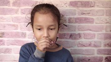 Young girl coughs into hand video