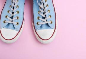 un par de viejas zapatillas azules desgastadas con cordones blancos foto